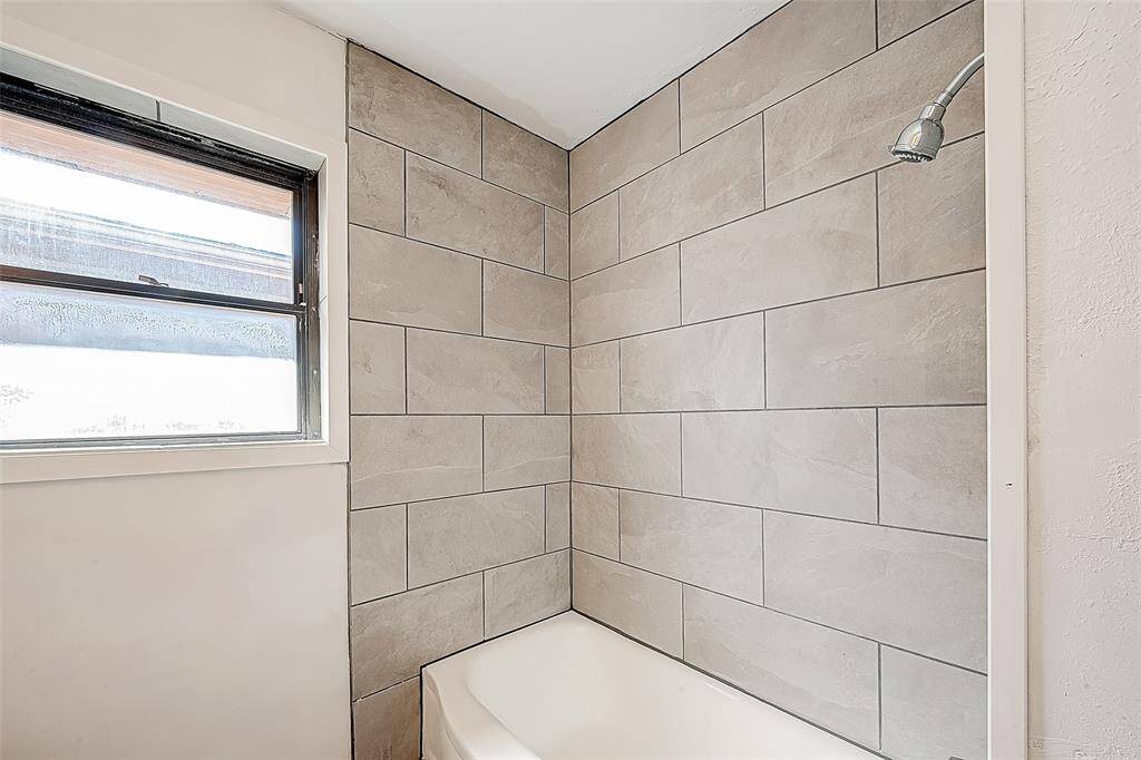 A TILE SURROUND IN THE SECONDARY BATHROOM IS SURE TO PLEASE A DISCERNING BUYER. THE ORIGINAL TUB HAS BEEN REFINISHED.