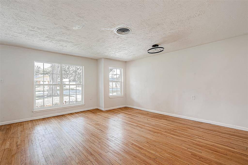 THE SIZABLE FAMILY ROOM OVERLOOKS THE FRONT YARD WITH WIDE WINDOWS. TAKE NOTE OF THE UNIQUE CEILING FAN/LIGHT FIXTURE WITH REMOTE CONTROL.