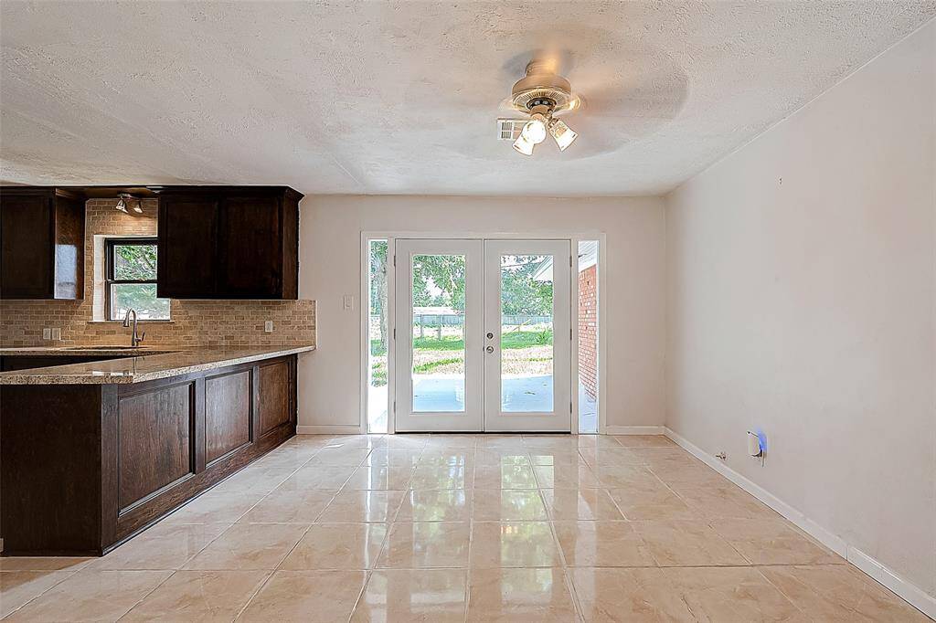 THE FORMAL DINING AREA OFFERS TILE FLOORING AND FRENCH DOORS OVERLOOKING THE BACKYARD AND BAYOU. NO BACK NEIGHBORS!