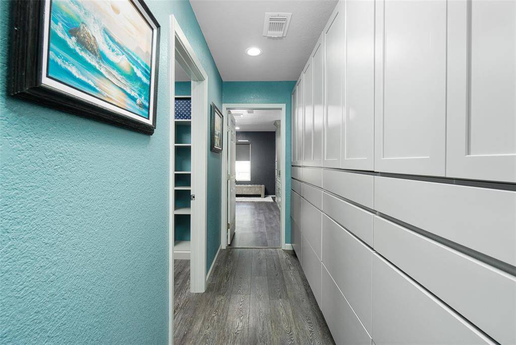 The primary bedroom is painted a coastal color, with recent luxury vinyl plank flooring, and french doors to the deck