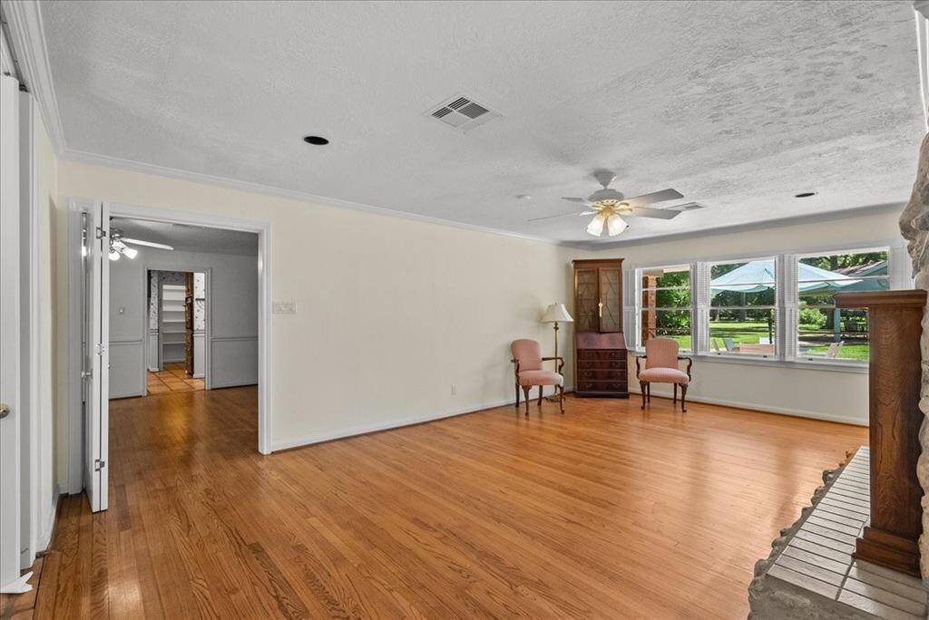 Step into timeless elegance: This formal living room boasts original hardwood floors that whisper stories of the past, while a gas log fireplace invites warmth and comfort, creating the perfect ambiance for cherished moments.