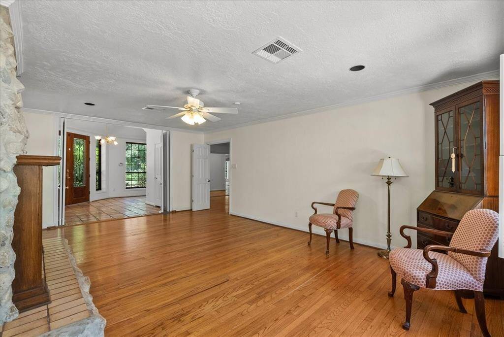 Enter a realm of refined sophistication: As you step into this formal living room, the allure of original hardwood floors beckons you to fall in love. Nestled within, a gas log fireplace offers more than warmth—it promises sanctuary, where cherished moments are born amidst an ambiance of unparalleled comfort and grace.
