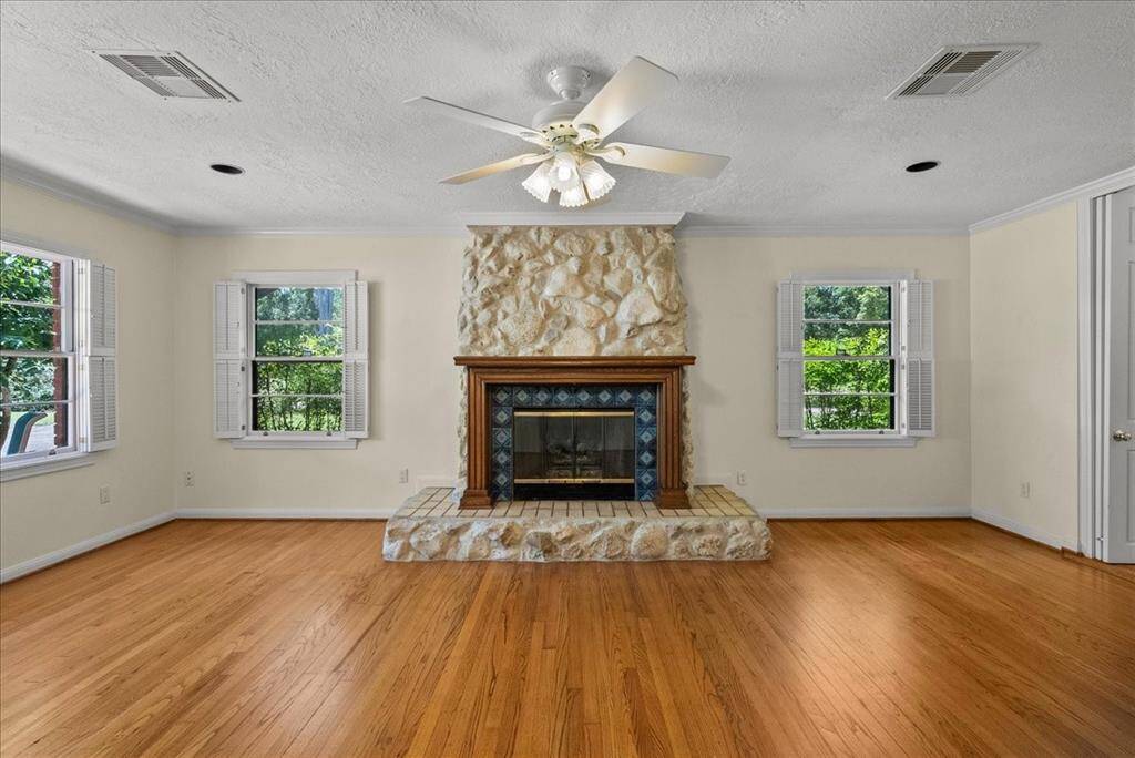 "Cozy evenings by the stone fireplace, framed by windows adorned with charming shutters, invite a blend of rustic charm and timeless comfort."