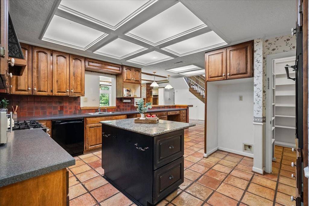 Discover timeless charm in this traditional-style kitchen, featuring durable solid-surface countertops and a spacious island complete with ample storage solutions.