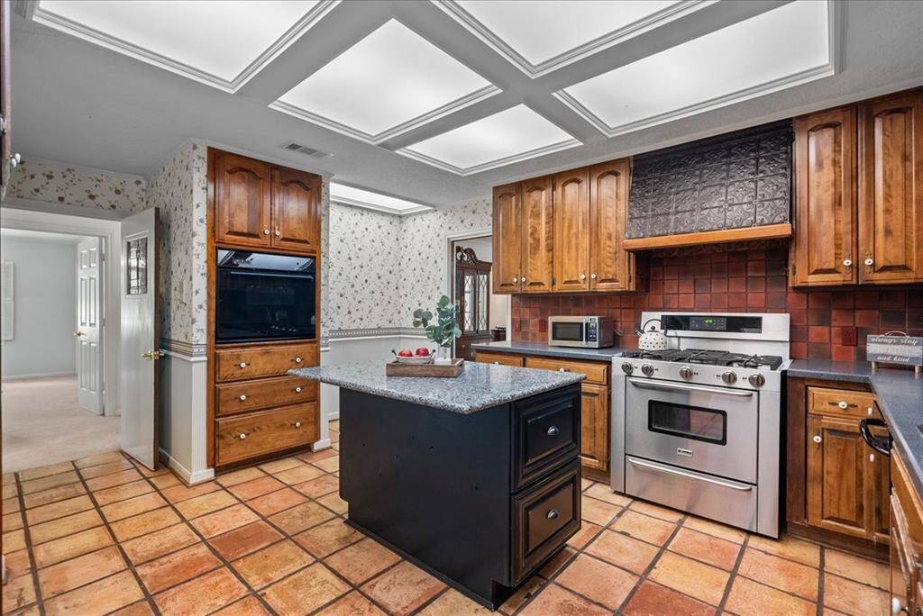 Experience culinary delights with gas cooking in this kitchen, where the versatile island serves as both a convenient serving area and a cozy spot to chat with the family chef.