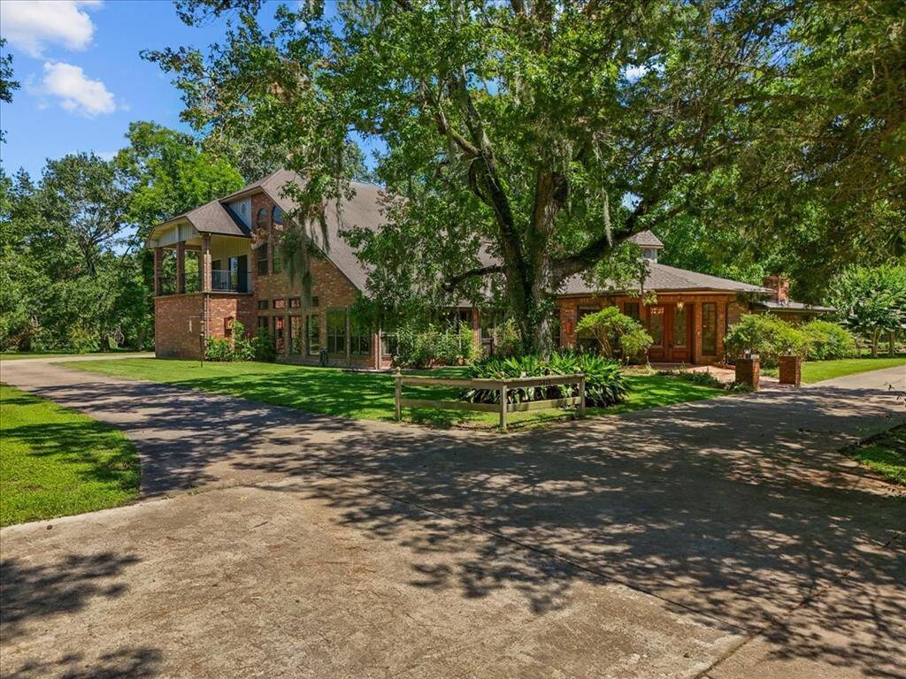 "Elegance in nature: A stunning estate nestled on 1.6 acres, surrounded by the timeless beauty of trees draped in Spanish moss."