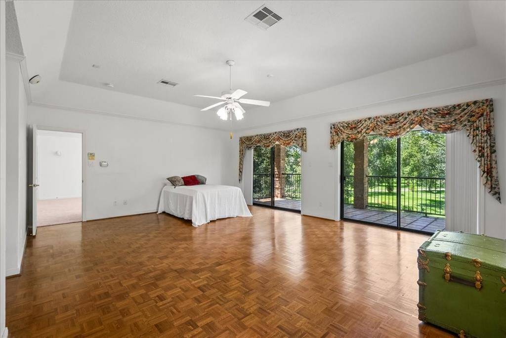 Unleash your Texas-sized furniture in this remarkable primary bedroom, boasting stunning views of the outdoors that complement its expansive allure.