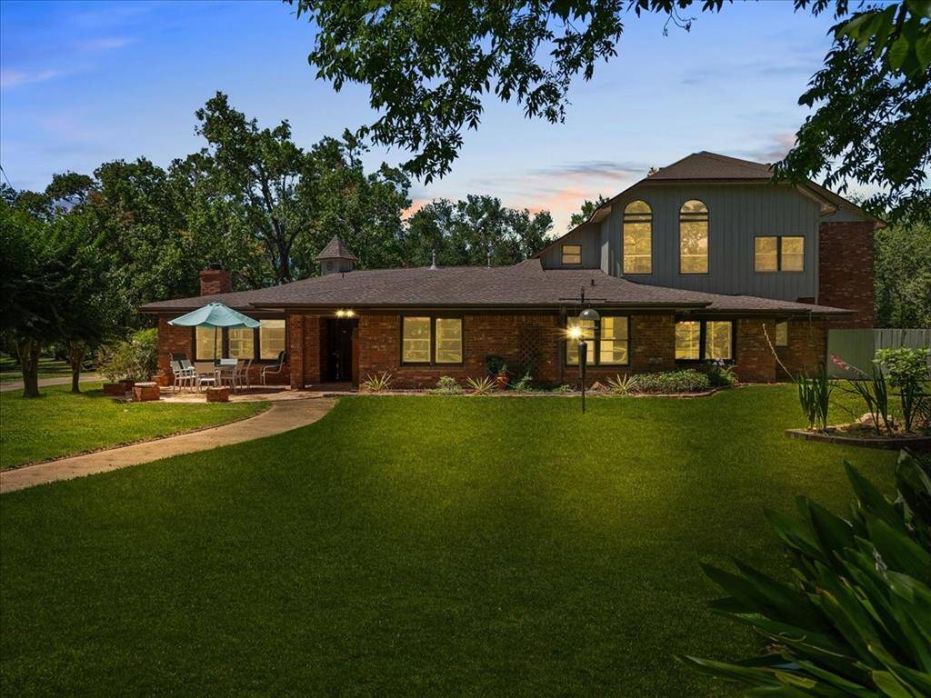 "Twilight serenity: A beautifully manicured lawn leads to a warmly lit haven, where home meets tranquility."