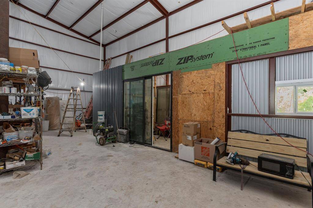 Inside the shop, there is an office that measures 14 feet by 8 feet, with an adjacent bathroom measuring 8 feet by 6 feet. Although the office is operational, it remains largely incomplete. Additionally, there are bathroom drains and hookups just outside the office walls, intended for a separate bathroom for the shop workers.
