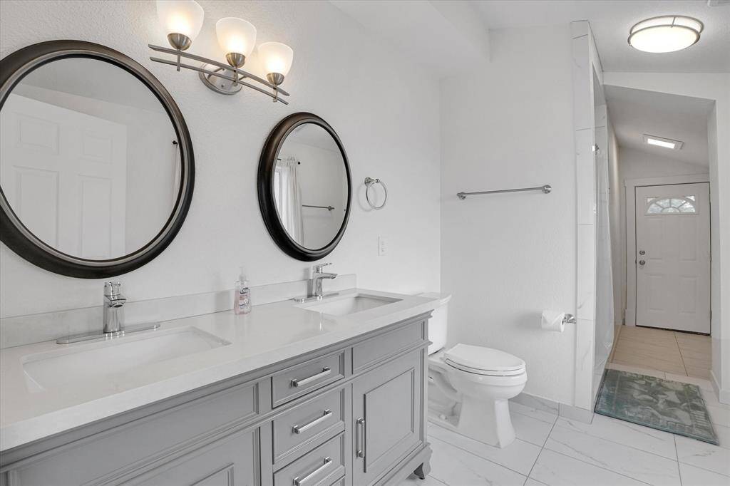 En-suite full bath in bedroom #4. Note exit door leading to rear stairs.