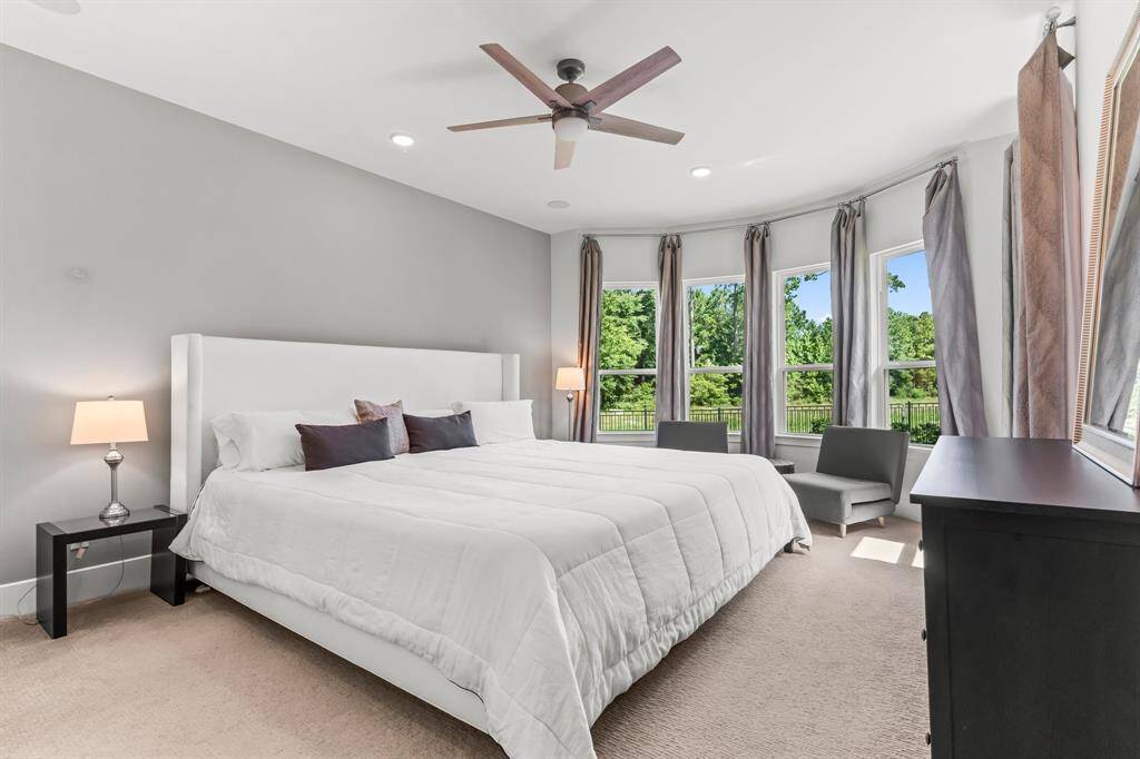Primary bedroom with large window allowing views over the backyard and reserve