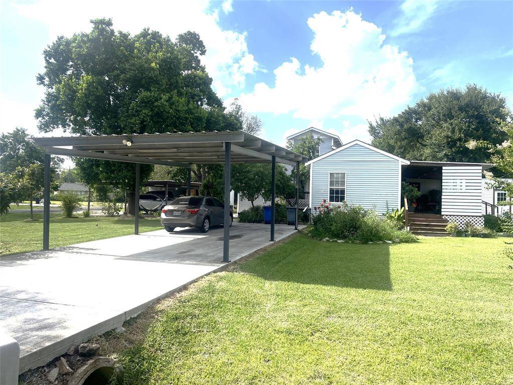 Front view with double-wide & concreted covered carport/driveway off Archwood St. is large enough for 4-6 vehicles