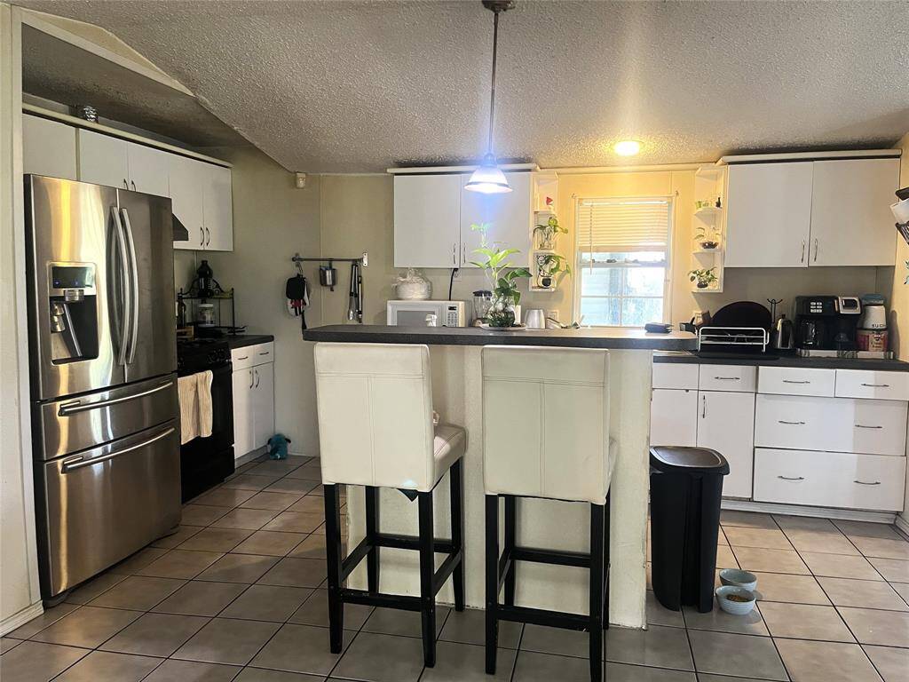 Island Kitchen with tile flooring and gas range