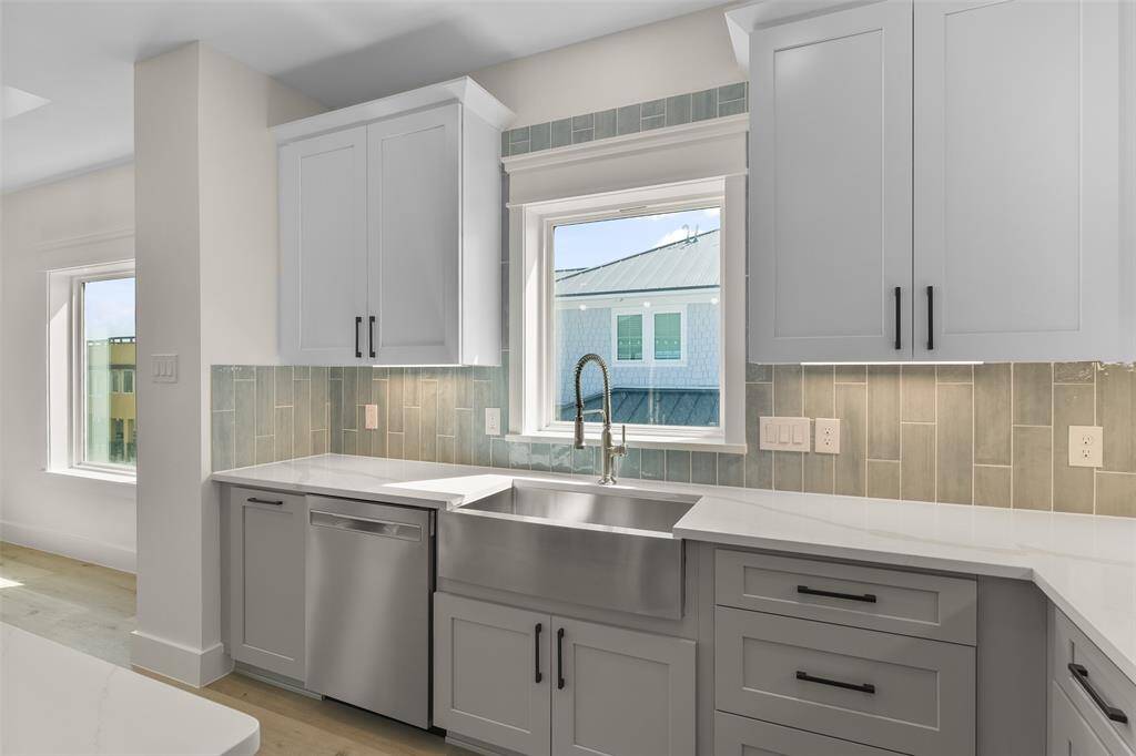 Enjoy serene bay views from the spacious apron sink in this beautifully appointed kitchen.