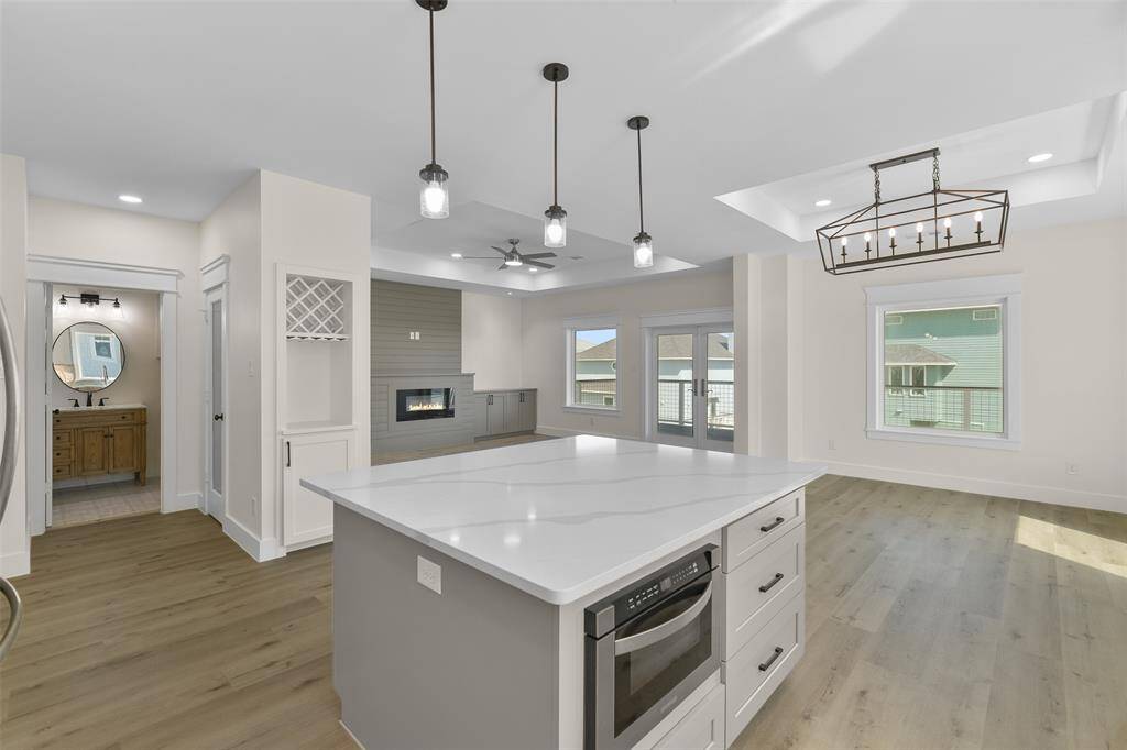 The open-concept kitchen, complete with a walk-in pantry and built-in wine storage, flows into the living and dining area.