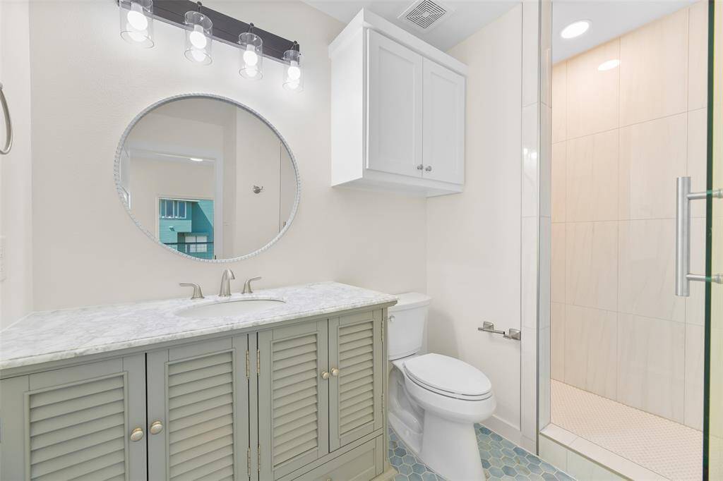 Bathroom number two features a coastal vanity, and walk-in shower.