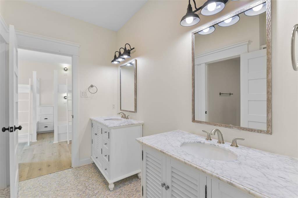 The adjoining bathroom features two separate vanities.
