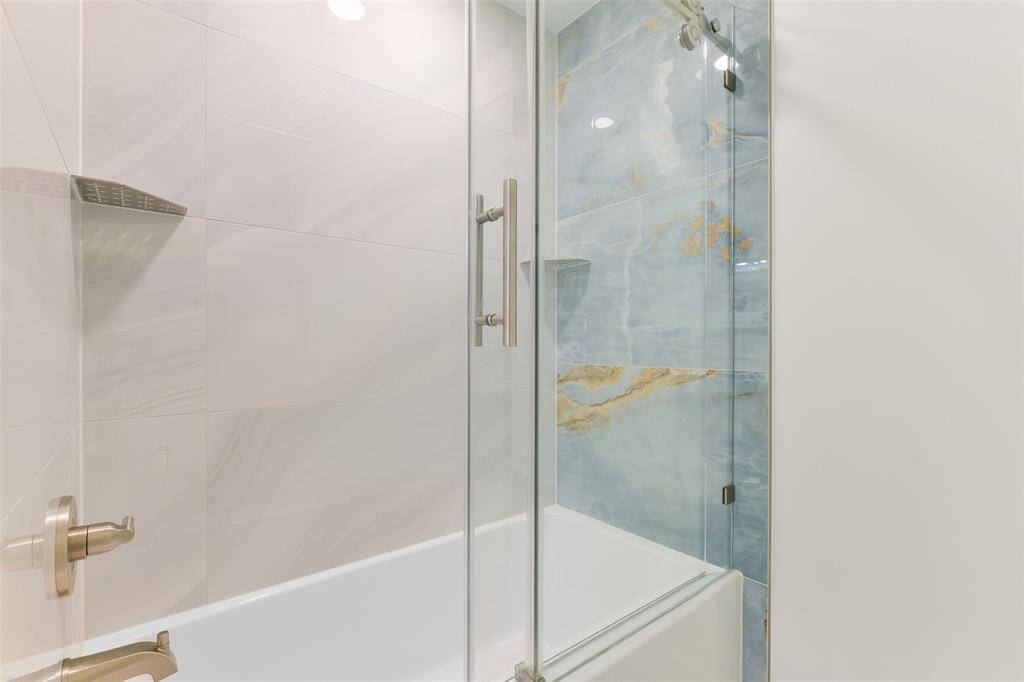 The beautifully tiled tub/shower combination in the adjoining bathroom.