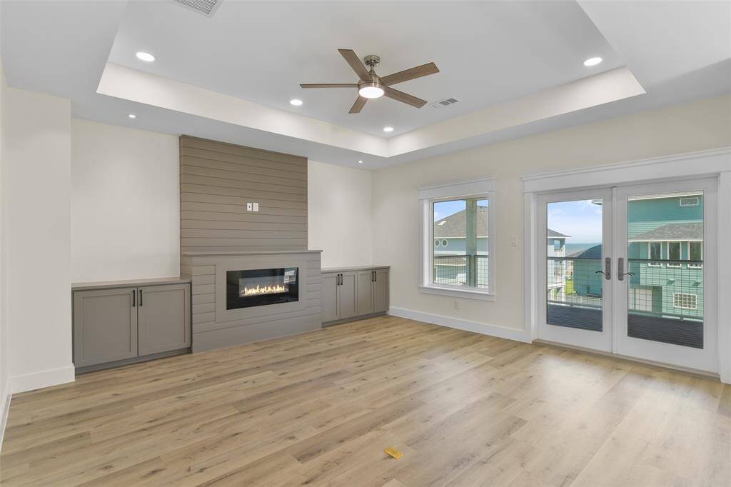 Lets start on the third floor! The open concept living room is full of natural light, a ship lapp fireplace, and a wall of windows bringing the views of the beach indoors.