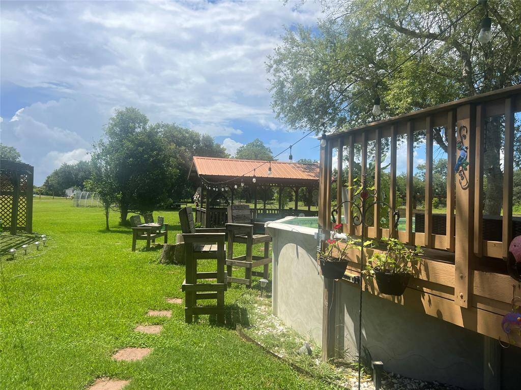 This is a spacious backyard with a well-maintained lawn, featuring an inviting deck area and a gazebo, perfect for outdoor dining and relaxation. The setting is ideal for those who enjoy open green spaces and entertaining guests.