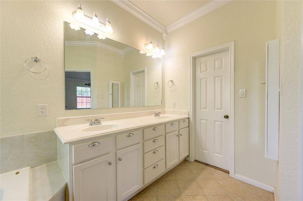 Elegant en-suite bath with dual vanities and ample natural light.