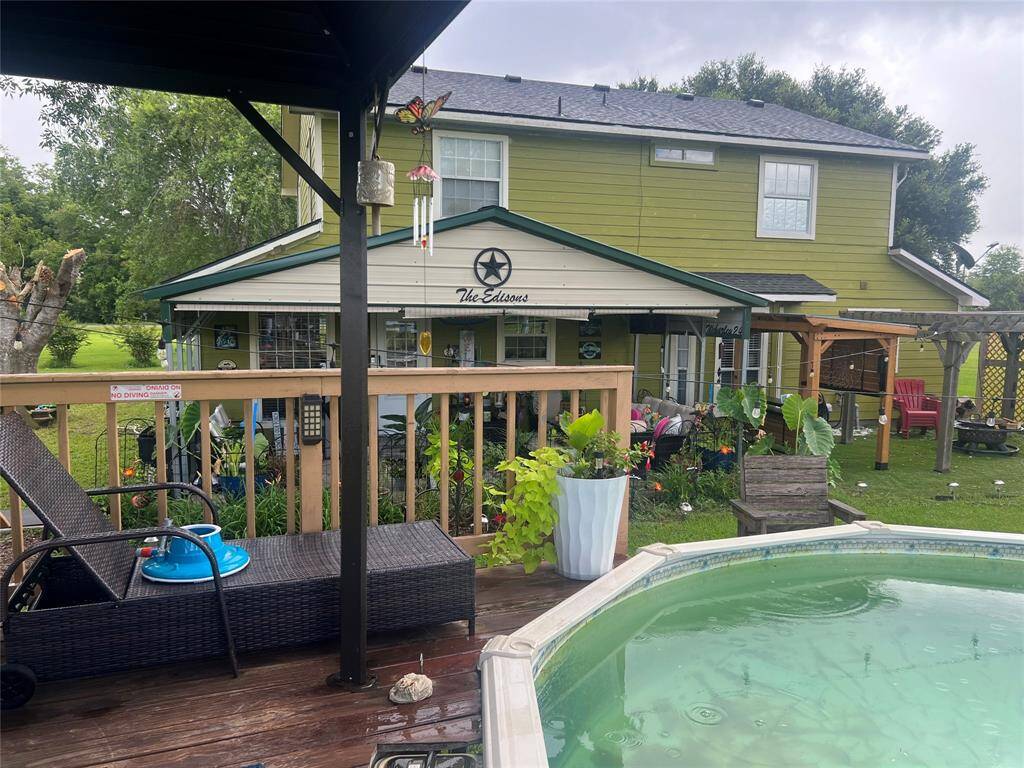 Charming two-story home with a spacious backyard featuring a covered deck, above-ground pool, and mature landscaping. A cozy outdoor living space perfect for relaxation and entertaining.
