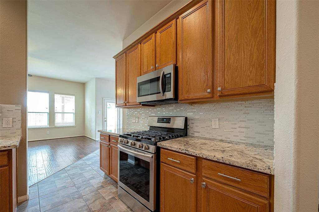 Custom granite counters with upgraded, neutral backsplash.