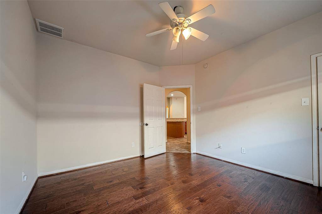 Across the kitchen are two of the three secondary bedrooms. Bedroom 1 with fan and walk-in closet