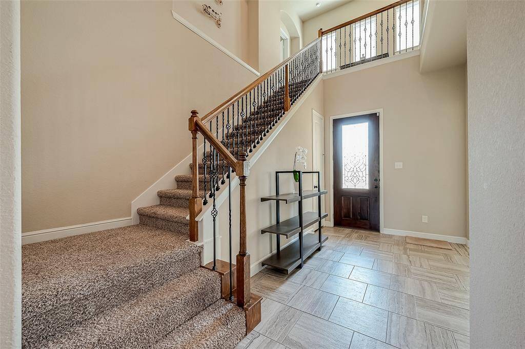 Stunning foyer features beautiful leaded glass door and wrought iron spindles.