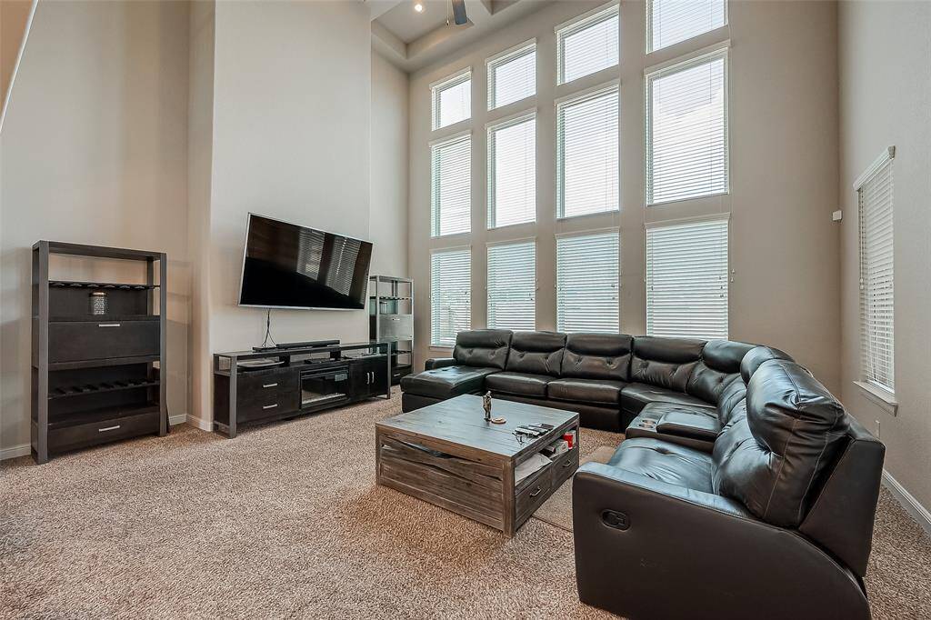 Soaring ceiling extends to the second floor. An abundance of natural light from the wall of windows.