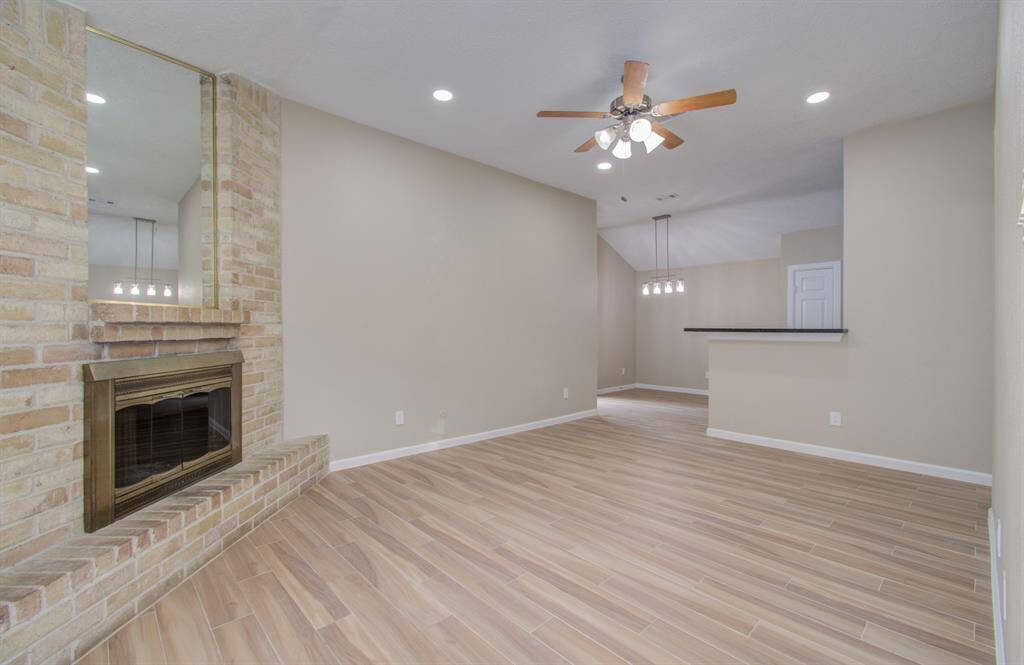 Spacious open-concept living area with a cozy fireplace, perfect for entertaining.