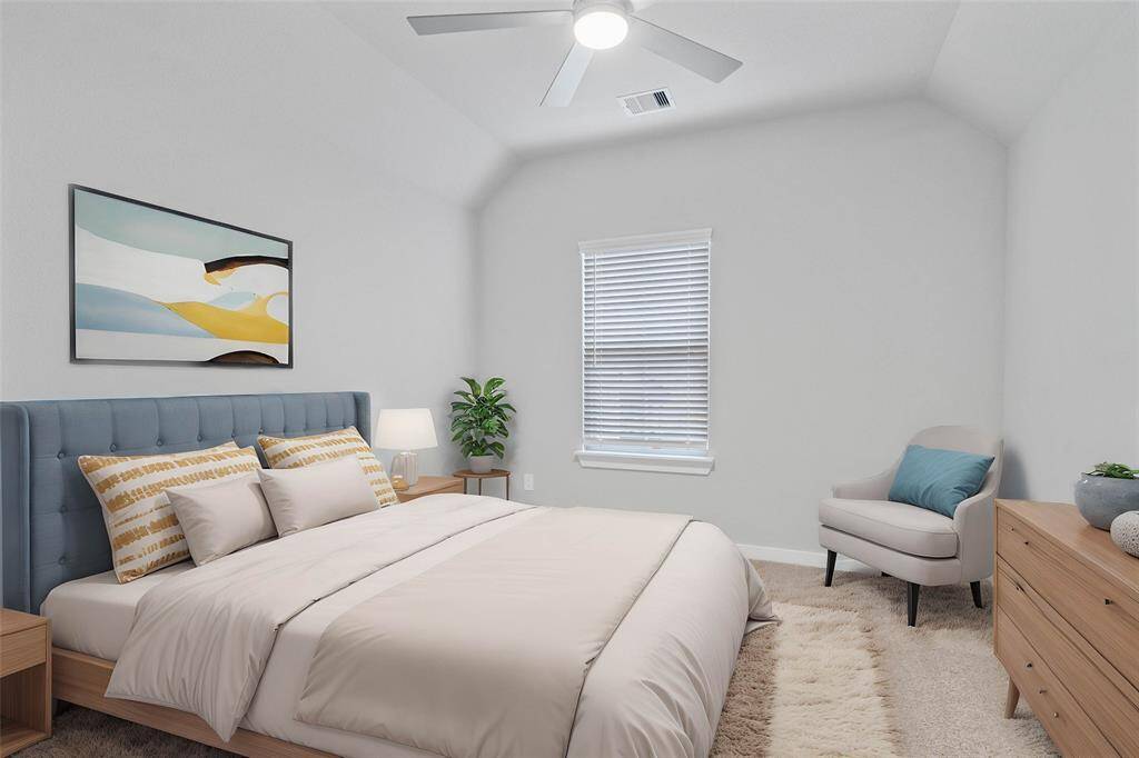 Secondary bedroom features plush carpet, custom paint, ceiling fan with lighting and a large window with privacy blinds.