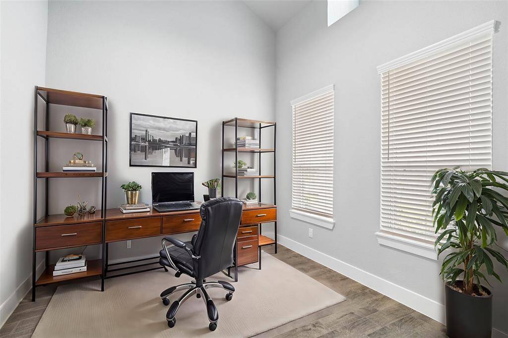 Quietly nestled in front of the home is the handsome home office. Featuring gorgeous wood look tile flooring, custom paint and large windows with privacy blinds.