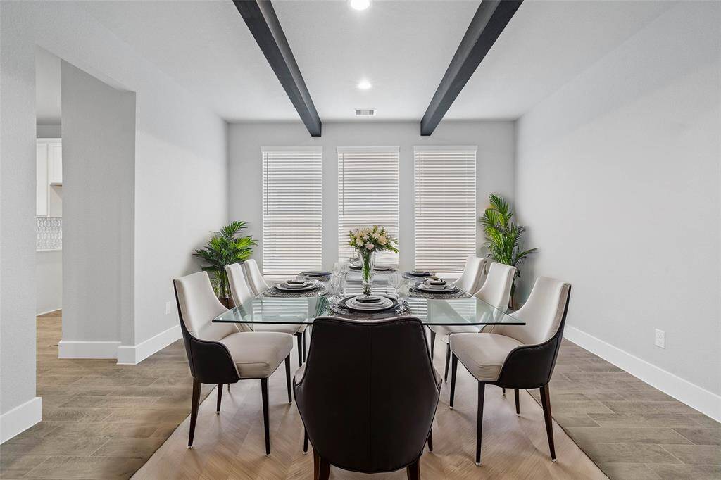 Make memories gathered around the table with your family and friends! This dining room features high ceilings with gorgeous wood beams, custom paint, recessed lighting, and large windows with privacy blinds.