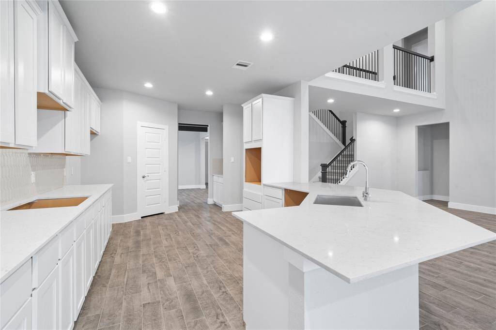 This kitchen is by far any chef’s dream! This spacious kitchen features high ceilings, white stained wood cabinets, quartz countertops, SS appliances, modern tile backsplash, recessed lighting, extended counter space, extra space for breakfast bar, and a walk-in pantry all overlooking your huge family room.