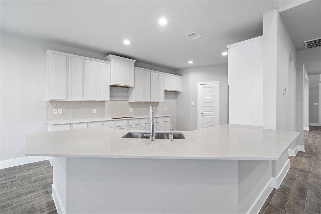 This kitchen is by far any chef’s dream! This spacious kitchen features high ceilings, white stained wood cabinets, quartz countertops, SS appliances, modern tile backsplash, recessed lighting, extended counter space, extra space for breakfast bar, and a walk-in pantry all overlooking your huge family room.