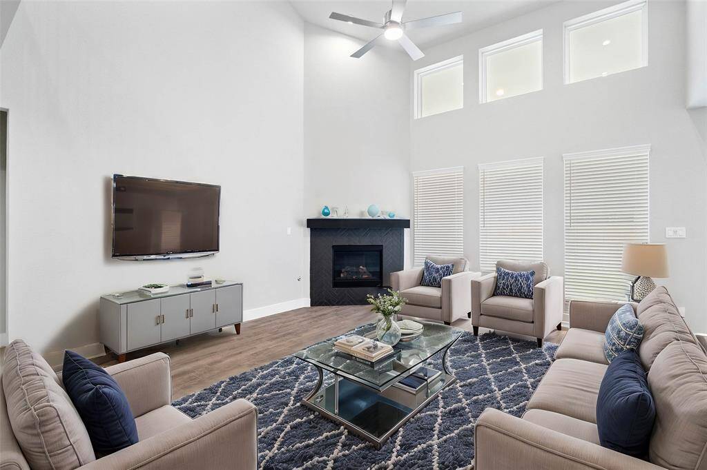 Gather the family and guests together in your lovely living room! Featuring a beautiful fireplace with wood mantel, high ceilings with ceiling fan, custom paint, gorgeous tile floors and a wall of windows with privacy blinds that provides plenty of natural lighting throughout the day.