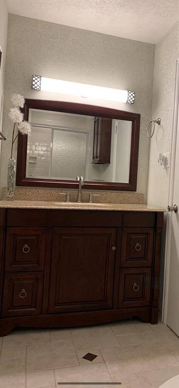 The primary bathroom features a granite counter, "kneehole" vanity, walk-in shower and walk-in closet.