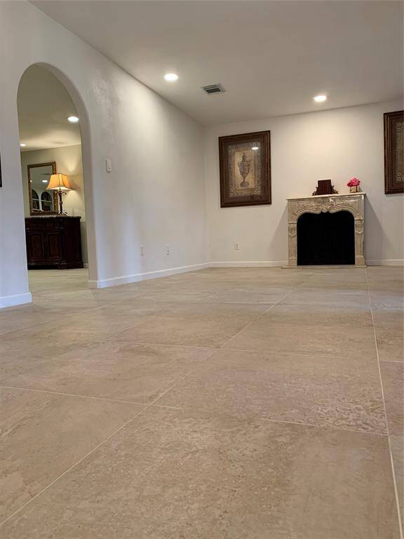 As you walk in the front door, the formal living room is located on the right with a mock fireplace. The arched doorway opens to the family room.