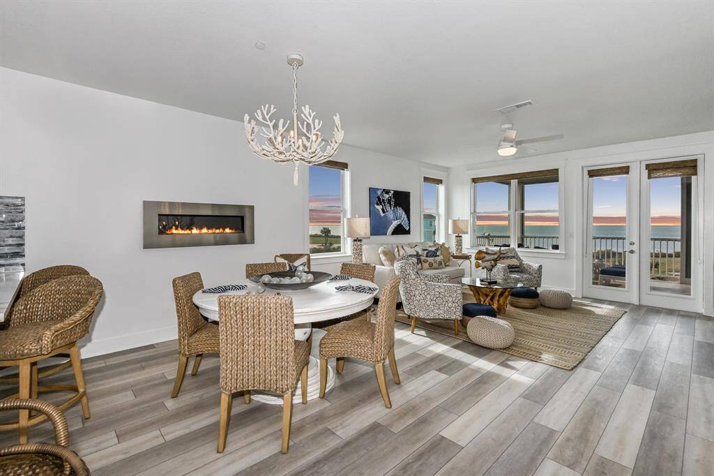 Revel in the luxury of updated flooring, custom chandelier, and unique fireplace feature while vast windows frame picturesque views, flooding the room with natural light.