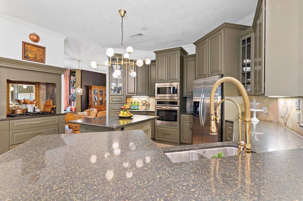 Large oversized kitchen with granite countertops, large island, under counter lighting.