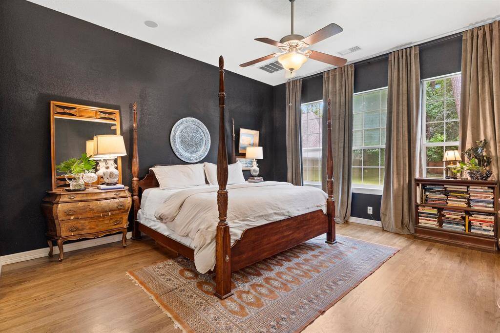 Primary suite with wood floors and high ceilings.