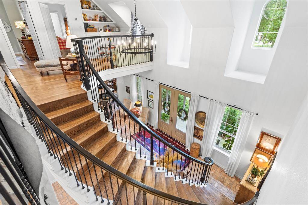 Sweeping wrought iron staircase with wood steps.