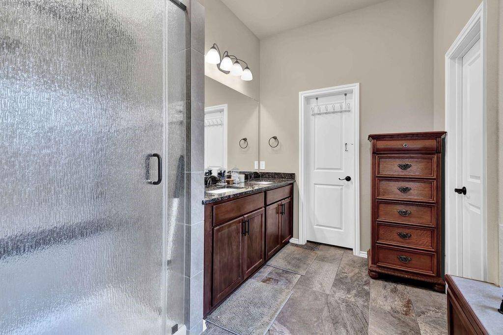 Primary bathroom shower with upgraded granite trim inside