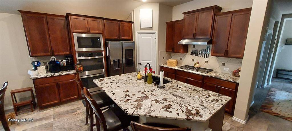Open kitchen with upgraded granite island and double ovens