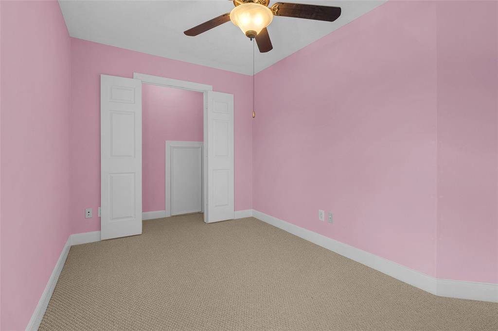 Discover a tranquil sanctuary with soft carpeting, abundant sunlight, and a sleek ceiling fan—perfect for unwinding in comfort.