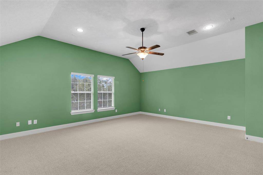Experience tranquil sophistication in this master suite, awash with abundant natural light and a harmonious color palette. A modern ceiling fan and plush carpeting ensure ultimate comfort in your private retreat.