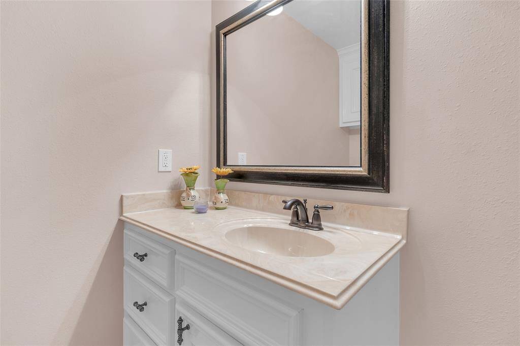 Modern bathroom with a corner soaking tub, a separate shower stall, and a toilet. Neutral tiles with decorative accents line the walls, and there's built-in cabinetry for storage.