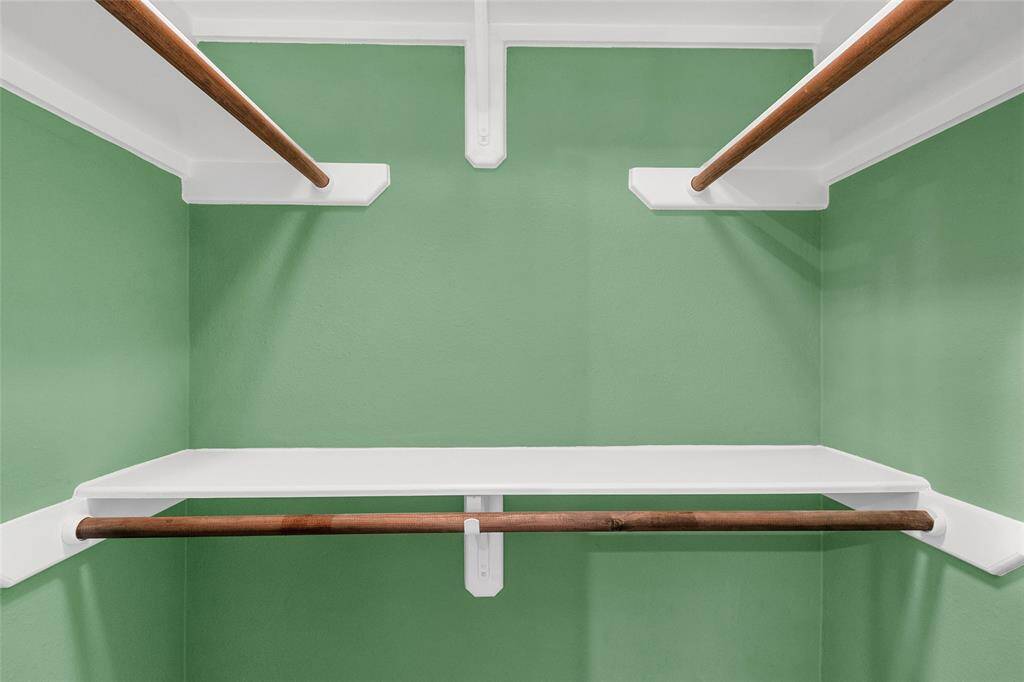 Walk-in closet featuring shelving and hanging rods offering ample space for storage and organization.