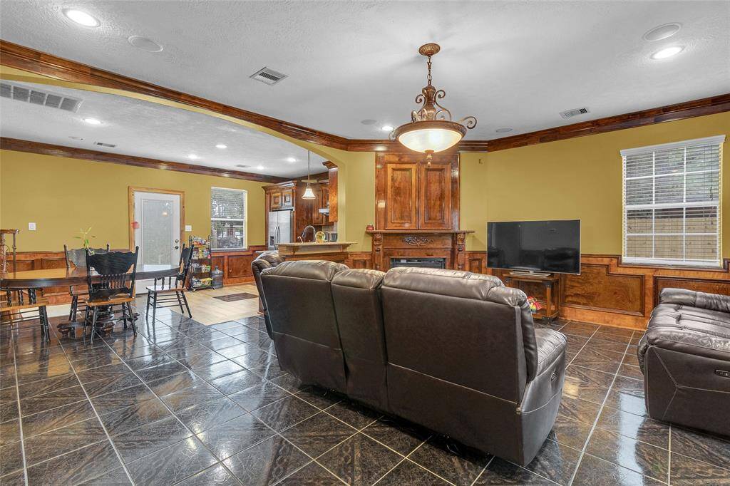 Discover serenity in this refined living area, boasting rich wood accents and a charming fireplace —ideal for both unwinding and lively gatherings.